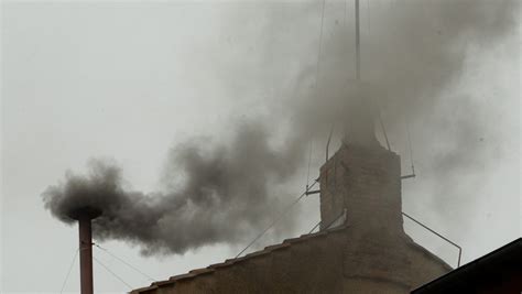 fotografia przedstawiająca dym unoszący się nad dachem dworu