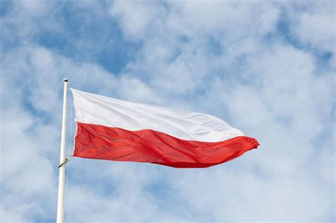 Tematyczne zdjęcie flagi OSP powiewającej na wietrze przed remizą