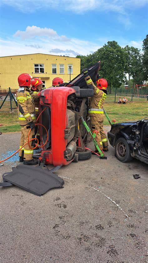 zdjęcie strażaków używających sprzętu hydraulicznego przy wraku samochodu