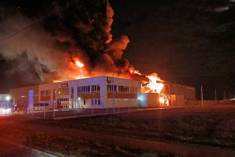 pożar magazynu, wozy strażackie, dym