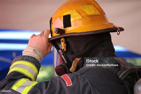 Photo of a firefighter adjusting their helmet
