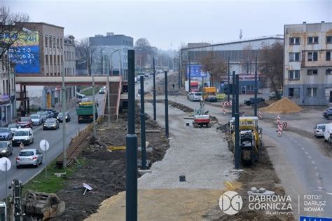Widok ogólny na ulicę w Dąbrowie Górniczej, tereny zielone, płaskie, z rowem odwadniającym.