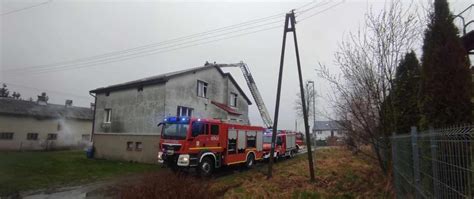 Zdjęcie przedstawiające akcję ratunkową straży pożarnej przed blokiem mieszkalnym