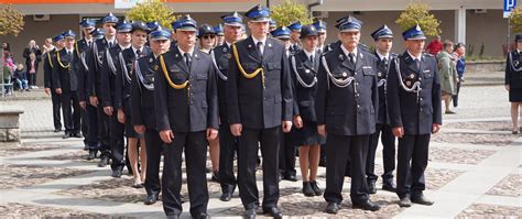 Strażacy OSP w umundurowaniu galowym podczas uroczystości państwowych, z widocznymi orderami i sznurami galowymi