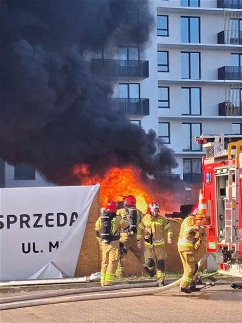 Zdjęcie przedstawiające gęsty dym nad osiedlem lub ratowników podczas akcji ewakuacyjnej