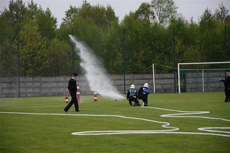Zdjęcie z zawodów sportowo-pożarniczych przedstawiające strażaków w akcji na boisku