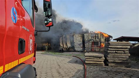 Widok na zniszczony warsztat samochodowy po pożarze w gminie Kamionka, z widocznymi uszkodzonymi pojazdami