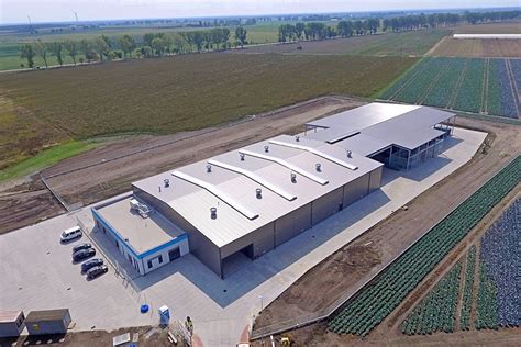 Widok na płonące hale produkcyjne w Nowej Wsi Rzecznej, duża chmura dymu widoczna z oddali