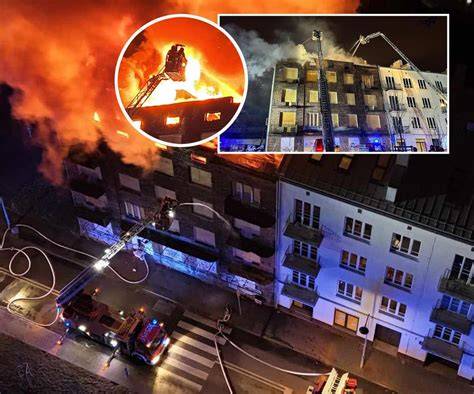 Strażacy gaszący pożar kamienicy na poddaszu w Warszawie