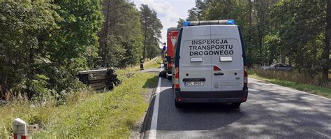 Zestawienie pojazdów ratowniczych na miejscu wypadku drogowego, w tym karetka, wozy strażackie i radiowóz policyjny