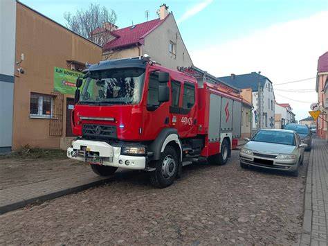 Zadymiona ulica w Zielonej Górze po pożarze kamienicy, wozy strażackie
