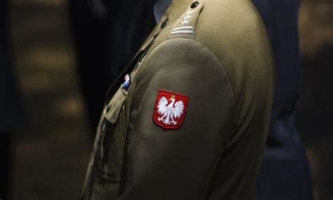 Zdjęcie zbliżenie na pagon, orzełek i naszywkę na mundurze strażackim