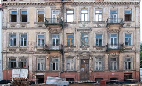 Zniszczona kamienica po pożarze, widoczne wypalone okna