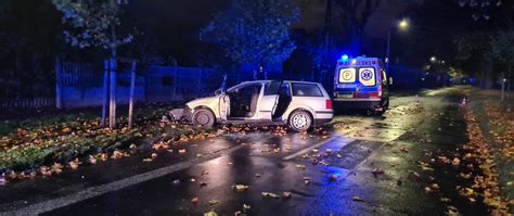 Zdjęcie spalonego samochodu osobowego na parkingu przy drodze, z widocznymi służbami ratunkowymi