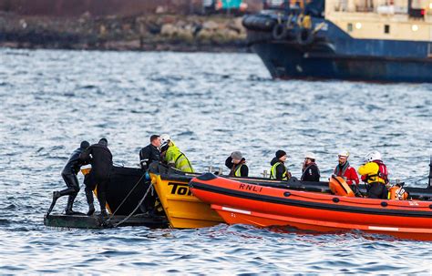 The rescue operation in the lake, including a boat and divers