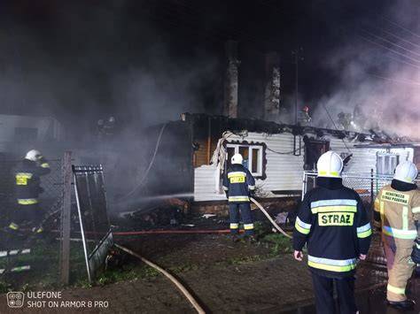 strażacy gaszący pożar w budynku