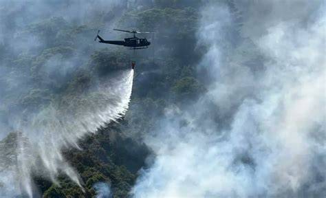 Thematic photo of a forest fire being extinguished from the air by a helicopter