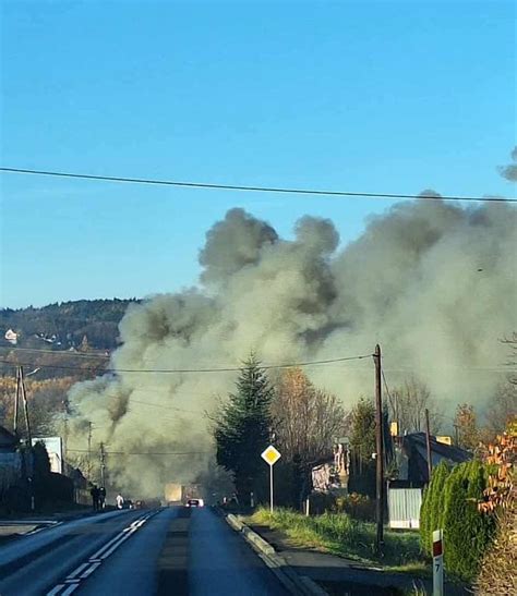 Zdjęcie przedstawiające gęsty dym nad wysypiskiem odpadów i strażaków w akcji