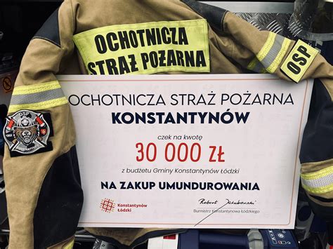 Zdjęcie druhów OSP podczas zebrania sprawozdawczego, z widocznymi sztandarami i odznaczeniami.