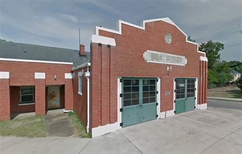 Thematic photo of a fire truck in front of an OSP fire station with old, wooden garage doors