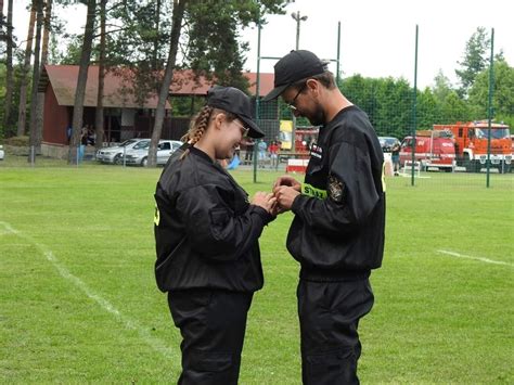 Uczestnicy gminnych zawodów strażackich OSP w Ochle, prezentujący swoje umiejętności w konkurencjach sportowo-pożarniczych.