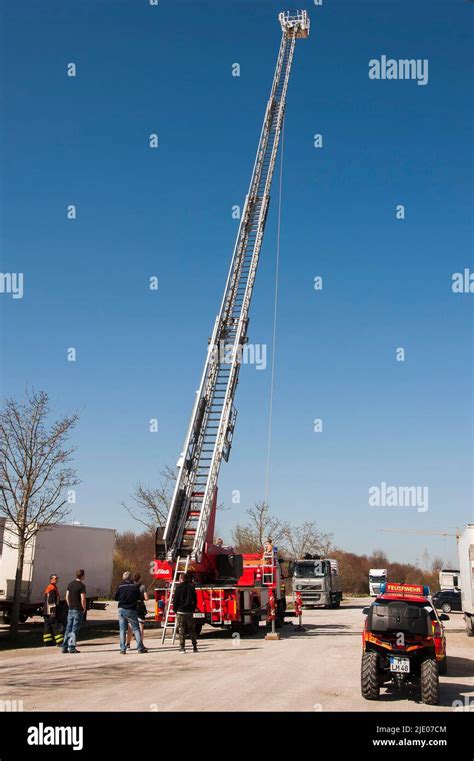 Thematic photo of a modern fire truck with an extended ladder reaching a building