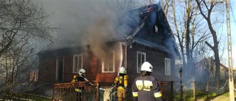 strażacy gaszą pożar domu