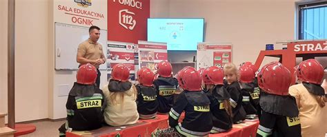 dzieci słuchające strażaka objaśniającego zasady bezpieczeństwa pożarowego