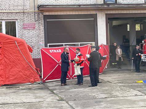Zdjęcie przedstawiające oficjalne przekazanie sprzętu ratowniczego strażakom przez przedstawicieli władz samorządowych