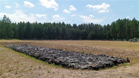 Widok na alejkę pamięci na terenie byłego Obozu Zagłady w Sobiborze, z kamieniami upamiętniającymi ofiary.