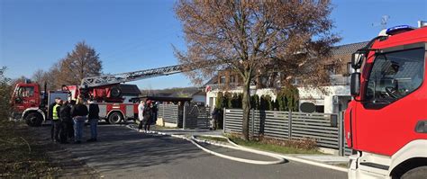Zdjęcie przedstawiające akcję gaśniczą straży pożarnej przy płonącym budynku jednorodzinnym