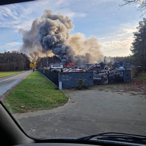 Zdjęcie z miejsca zdarzenia przedstawiające zniszczone przez ogień samochody na prywatnej posesji