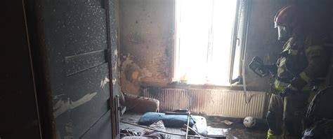 strażak z kamerą termowizyjną w zadymionym pomieszczeniu