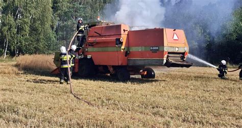 Zdjęcie przedstawiające akcję gaśniczą kombajnu na polu przez strażaków