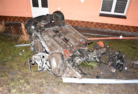 Zniszczony przez ogień samochód na prywatnej posesji, widoczne ślady działania służb