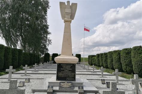Pomnik poświęcony poległym strażakom z wieńcami kwiatów