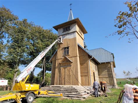 Tematyczne zdjęcie drewnianego kościoła o tradycyjnej konstrukcji, w tle malowniczy krajobraz
