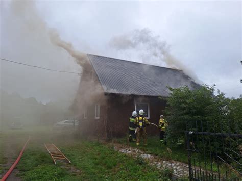zdjęcie dymiącego się budynku mieszkalnego podczas akcji gaśniczej