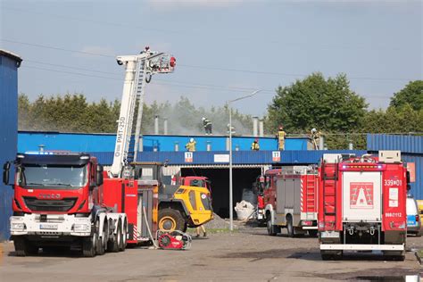 zdjęcie spalonej hali magazynowej i ciężarówek po pożarze