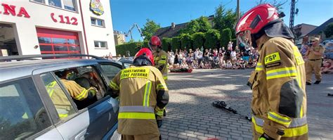 zdjęcie przedstawiające grupę dorosłych i dzieci obserwujących pokaz strażacki
