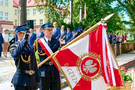 Zdjęcie z uroczystości strażackich w Twardogórze ukazujące poczty sztandarowe i wóz bojowy