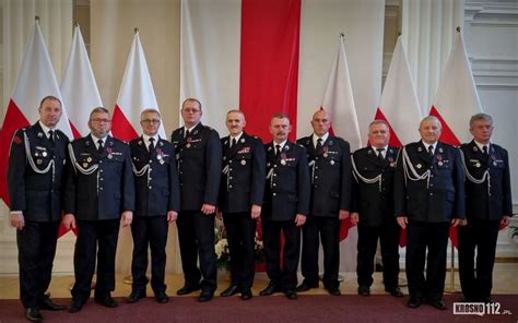 Zdjęcie strażaków odbierających odznaczenia lub awanse podczas uroczystości