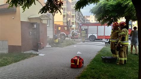 Strażacy gaszący pożar w budynku, silne zadymienie