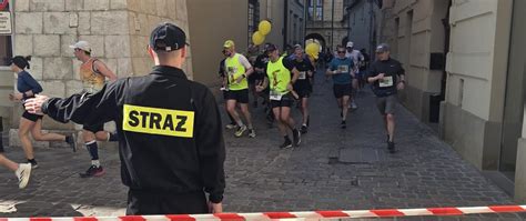 Zdjęcie przedstawiające startujących biegaczy na tle straży pożarnej