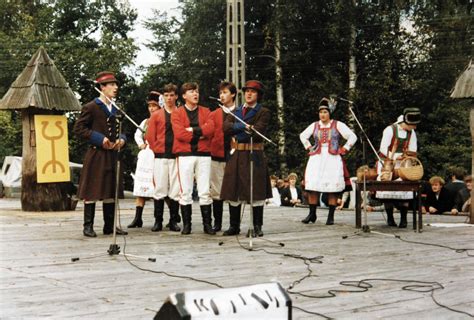 Zdjęcie przedstawiające uczestników w strojach z epoki i zabytkowe samochody na plaży