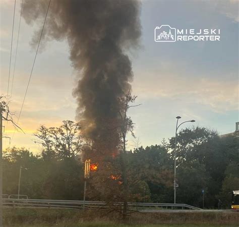 widok z lotu ptaka na płonący budynek, dym unoszący się z dachu i okien