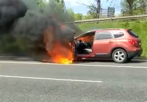 płonący samochód elektryczny na drodze
