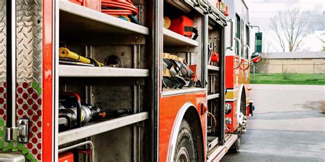 Zdjęcie przedstawiające typowe wyposażenie wnętrza wozu strażackiego, w tym walizki sprzętowe i elementy układu wodno-pianowego.