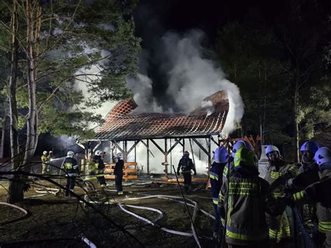 Strażacy dogaszający pogorzelisko domu letniskowego