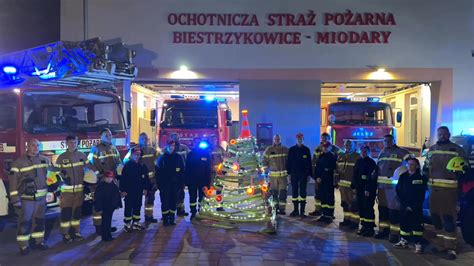 Zdjęcie przedstawiające akcję ratunkową straży pożarnej i ratownictwa medycznego w nocy, w pobliżu stawu, symbolizujące dramatyczne zdarzenie
